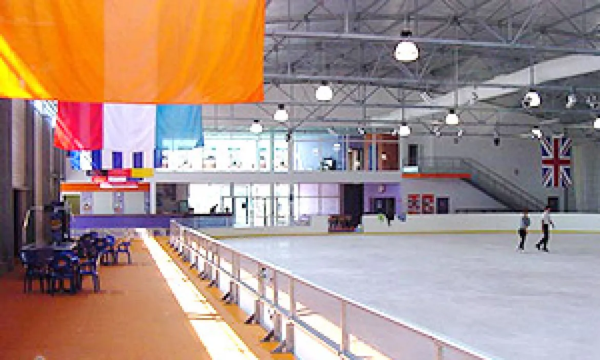 The ice and stands of CityGlace with the barrier, the glazed café mezzanine and the national flags overhead. — CityGlace