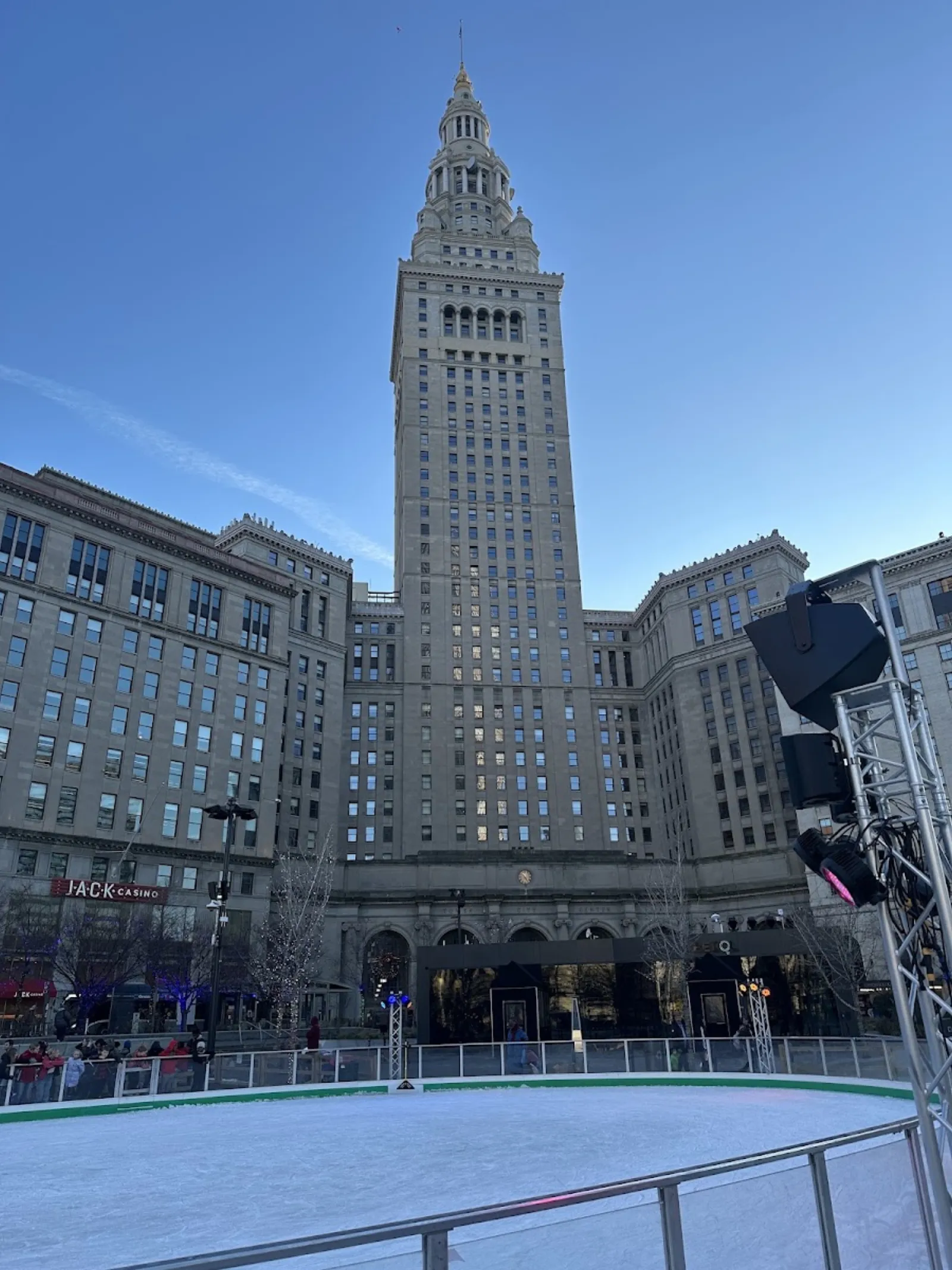 The Cleveland Foundation Skating Rink on Public Square at dusk, its empty ice edged by the railing, with the Terminal Tower rising behind — Cleveland Foundation Skating Rink
