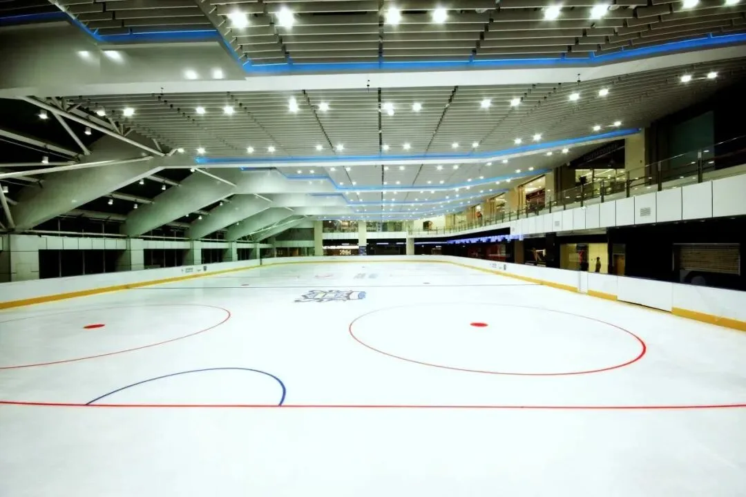 The Champion Rink's ice at Chaoyang Joy City, empty, with hockey markings and a ceiling of lights above the rink — Champion Rink, Chaoyang Joy City