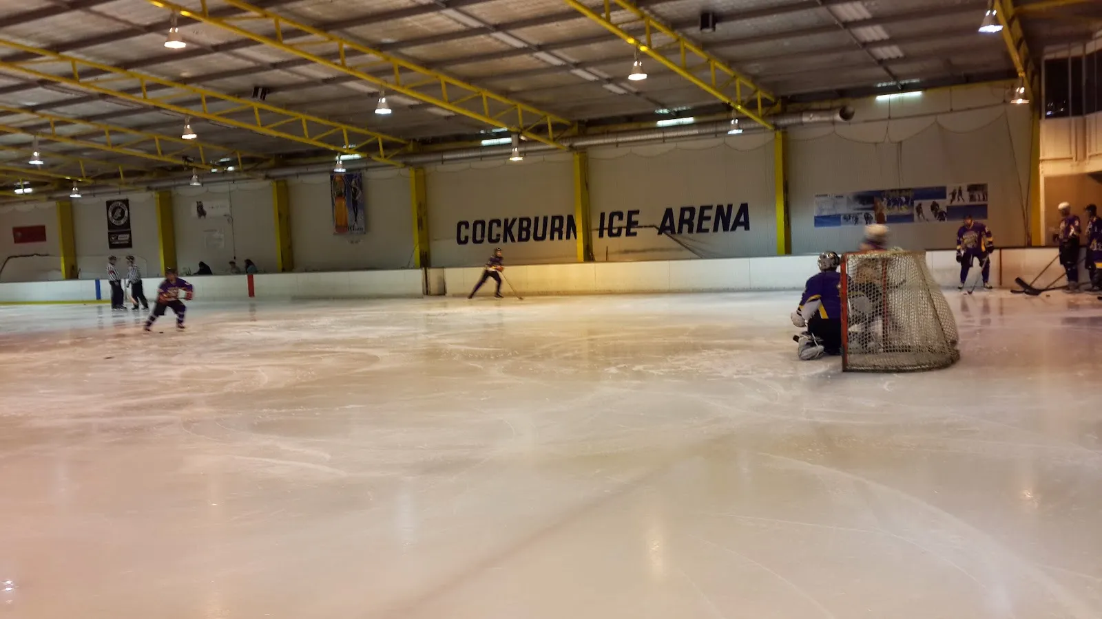 The ice at Cockburn Ice Arena with the arena name on the boards — Cockburn Ice Arena