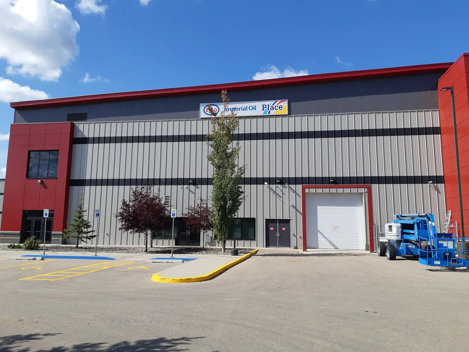 The red and grey metal-clad Cold Lake Energy Centre front with its overhead door and car park. — Cold Lake Energy Centre