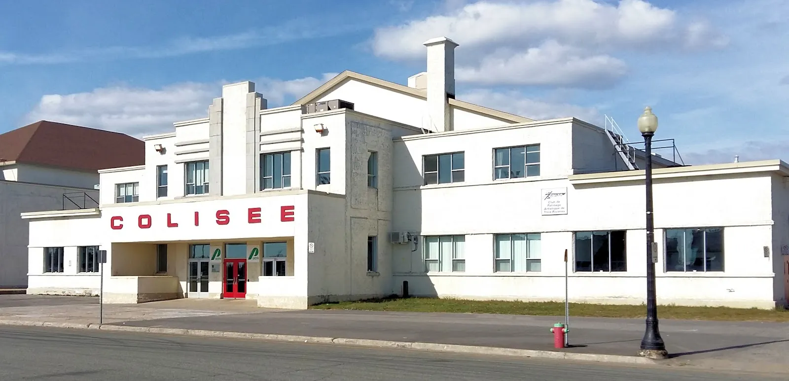 Le Colisée blanc de 1938, dans son style paquebot aux lignes profilées, avec « COLISEE » en lettres rouges au-dessus de l’entrée. — Colisée Jean-Guy-Talbot