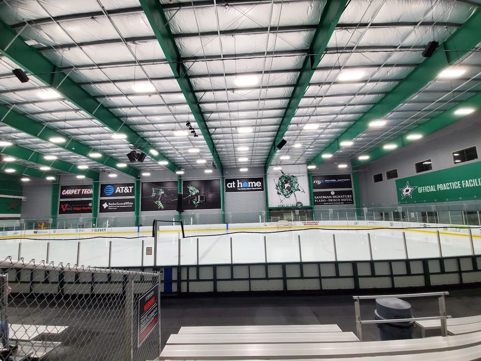 The Comerica Center practice sheet from the bleachers, empty under green steel beams with the Dallas Stars Official Practice Facility banner — Comerica Center (Frisco)