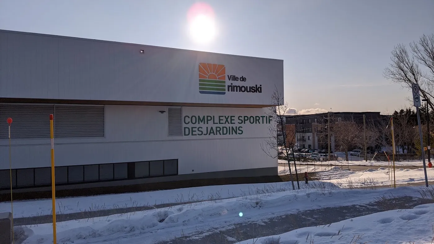 The Ville de Rimouski wall of the Complexe sportif Desjardins with its lettering, seen across the snow at low sun. — Complexe sportif Desjardins (Rimouski)
