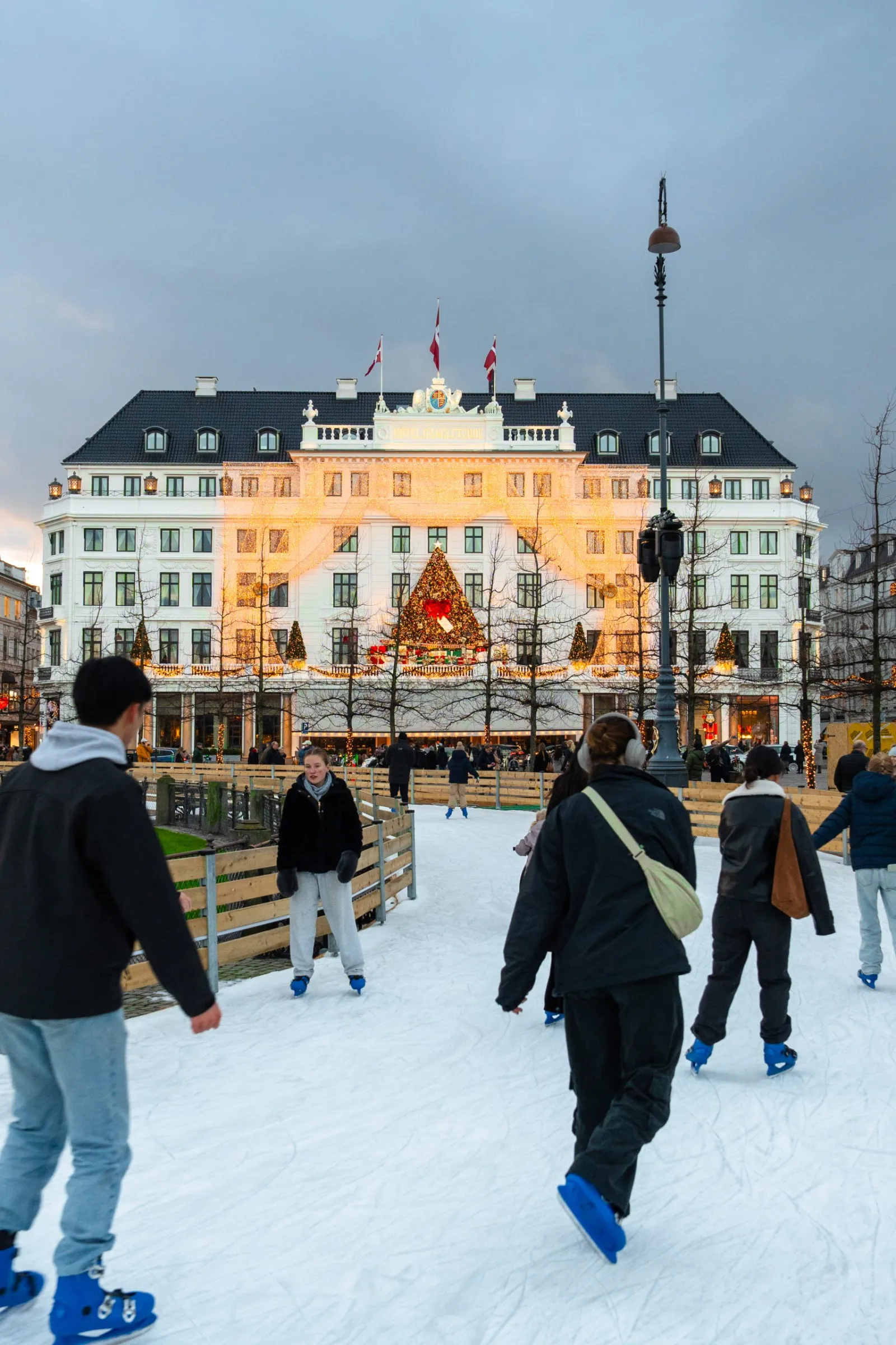 Skøjteløbere på banen på Kongens Nytorv med Hotel d'Angleterre bagved — Copenhagen Winter Wonderland (Kongens Nytorv)