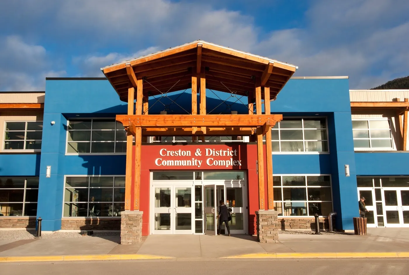The blue entrance of the Creston and District Community Complex under its timber-framed canopy. — Creston & District Community Complex