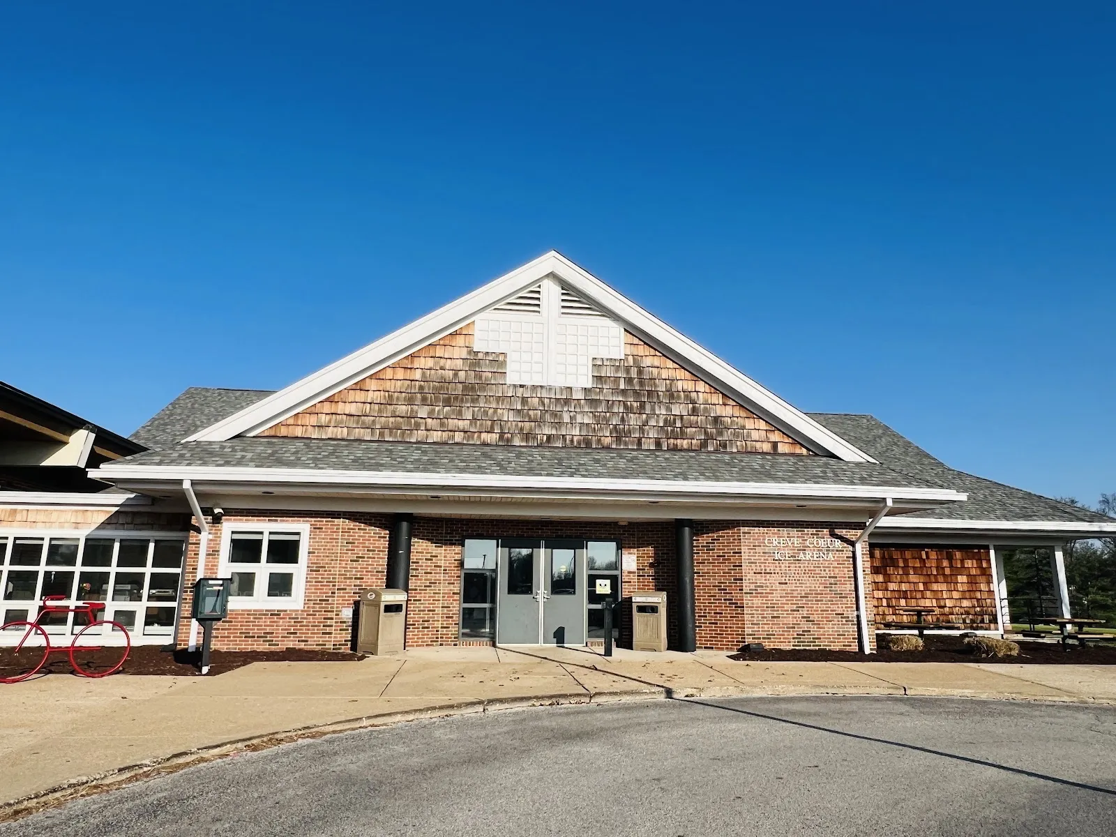 The gabled brick entrance of the Creve Coeur Ice Arena, with the arena's name lettered beside the front doors — Creve Coeur Ice Arena