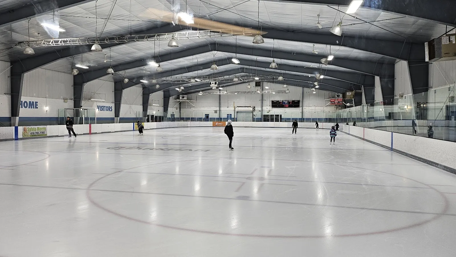 Un patinaje público en el hielo del Crosby Memorial Community Centre en Unionville, con patinadores repartidos bajo el techo de acero — Crosby Community Centre