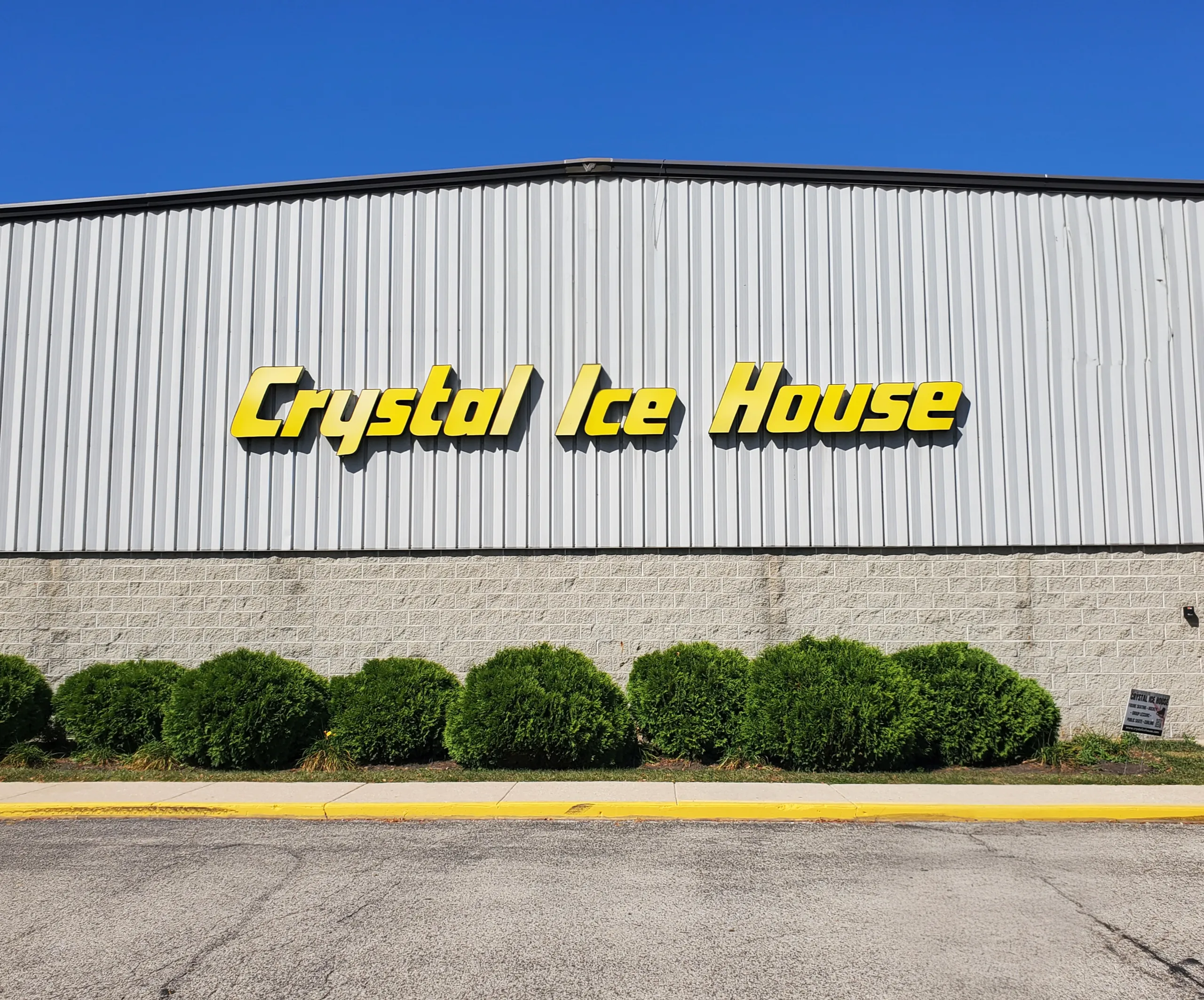 Yellow lettering across the corrugated metal facade — Crystal Ice House (Crystal Lake)
