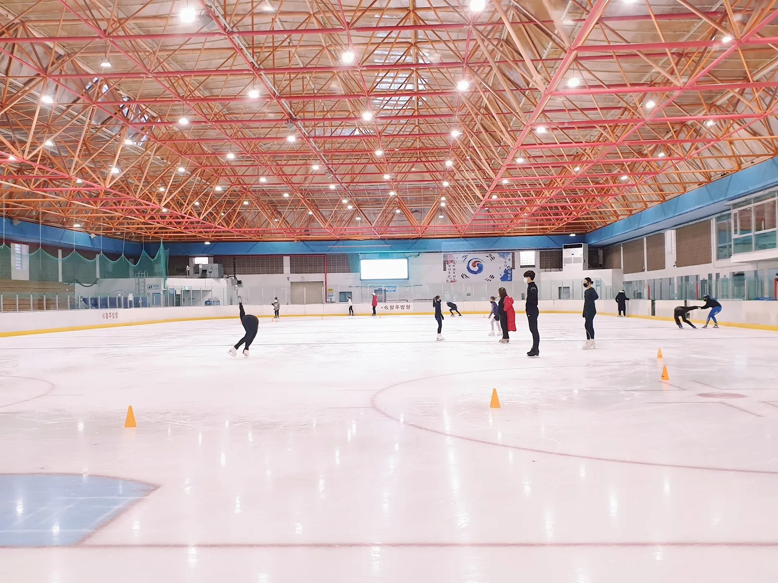 스케이터들이 있는 대구실내빙상장의 빙판과 지붕 — Daegu Indoor Ice Rink