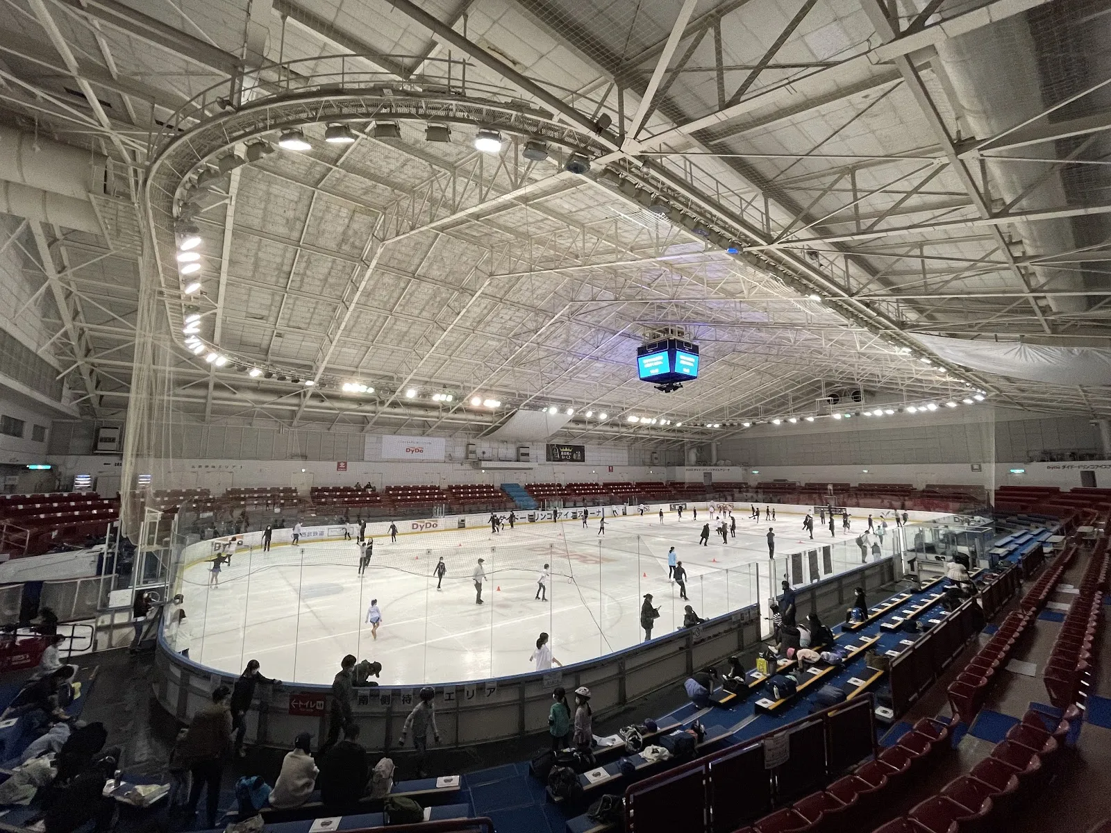The whole ice sheet and stands of the Dydo Drinco Ice Arena during a public session, seen from the stand — Dydo Drinco Ice Arena