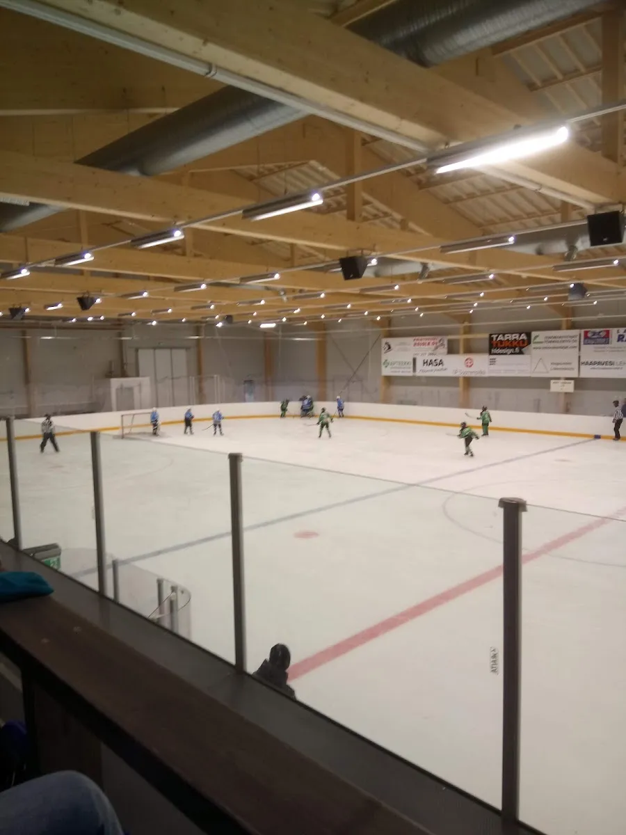 Players scattered across the Haapavesi ice hall rink under a timber roof, seen from the stand. – Darekon Areena