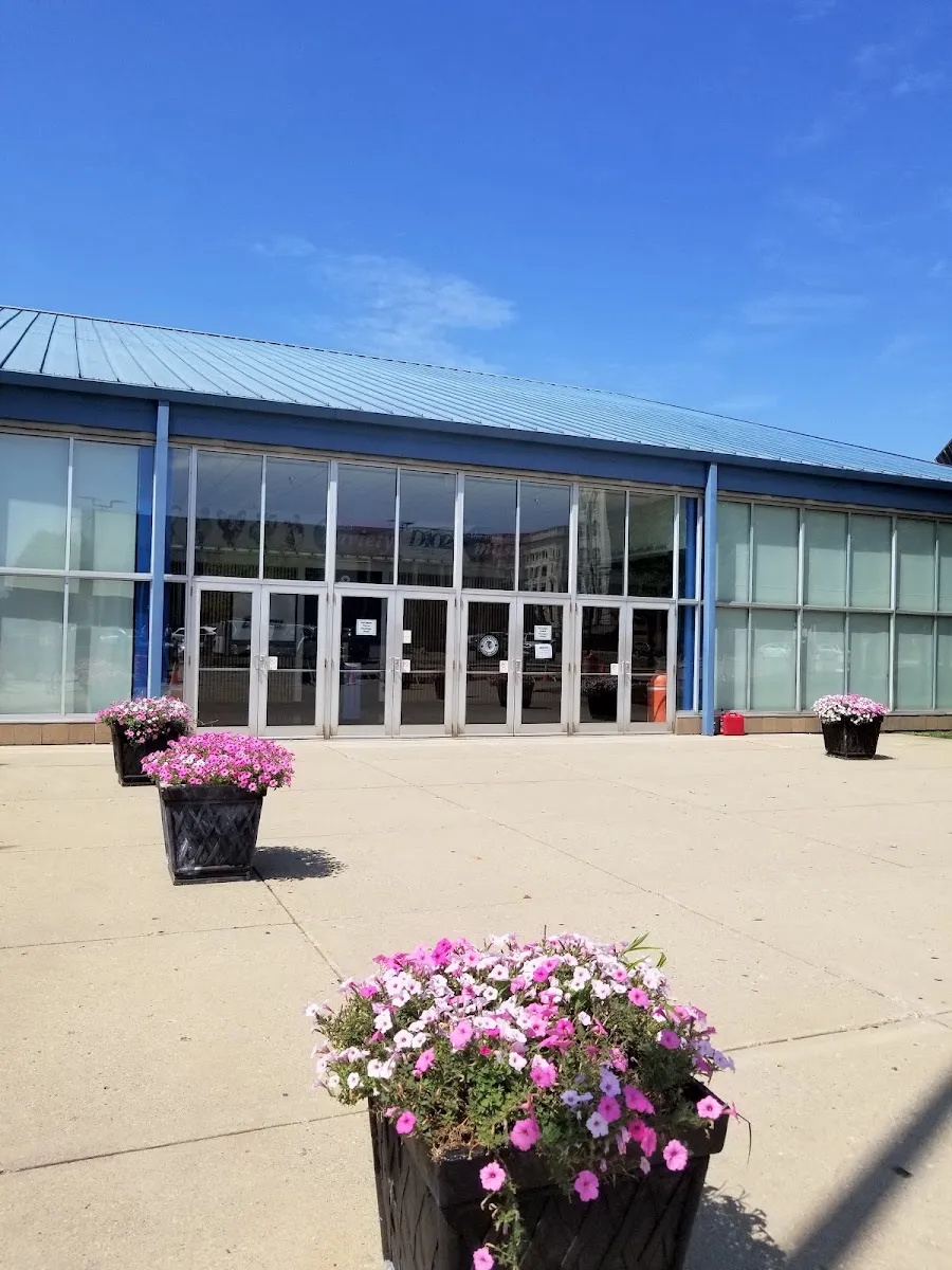 The glass-fronted main entrance of David S. Palmer Arena in Danville with planters on the plaza — David S. Palmer Arena