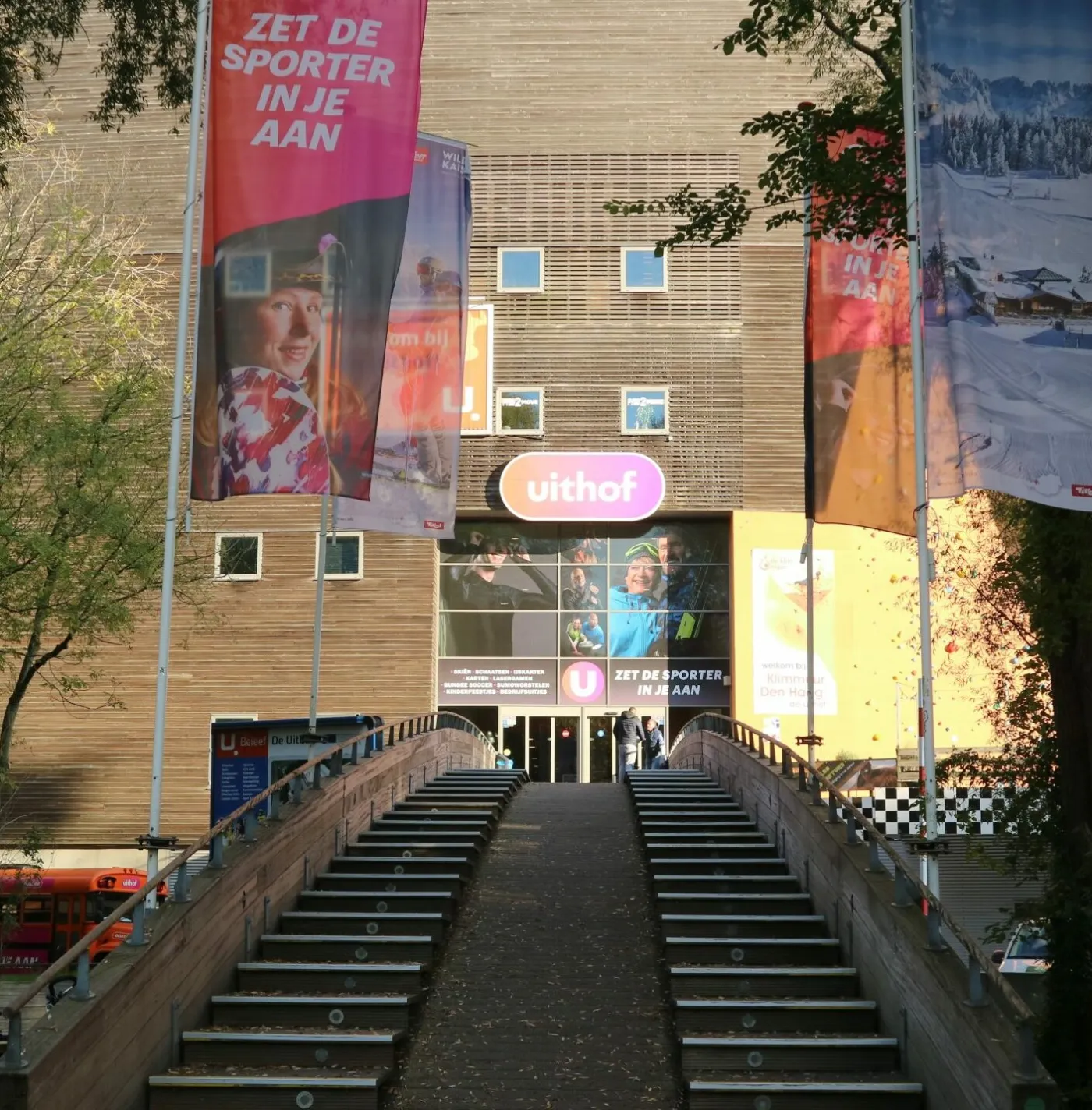 The entrance of De Uithof at the top of the steps, with the building's brick front and banners — De Uithof