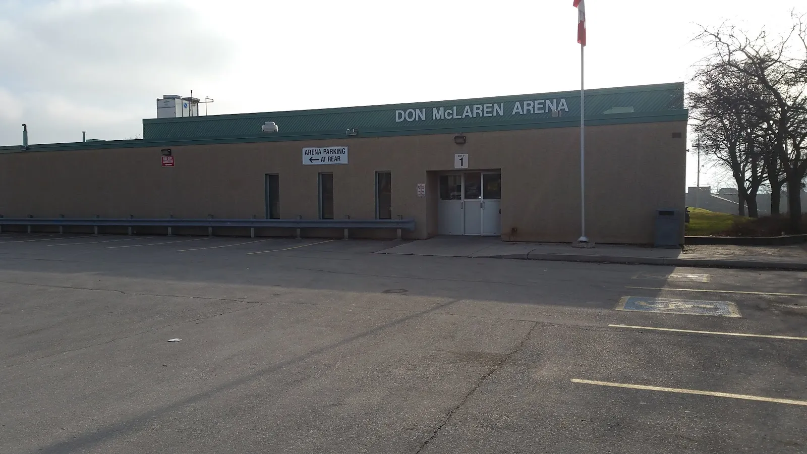The low brick front of Don McLaren Arena with its name on the roof fascia, a flagpole and the car park in front. — Don McLaren Arena