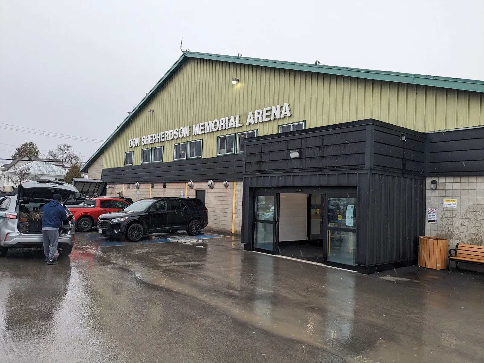 El Don Shepherdson Memorial Arena de paredes verdes en New Liskeard, con su nombre en el frente y una entrada de vidrio negro. — Don Shepherdson Memorial Arena (New Liskeard)