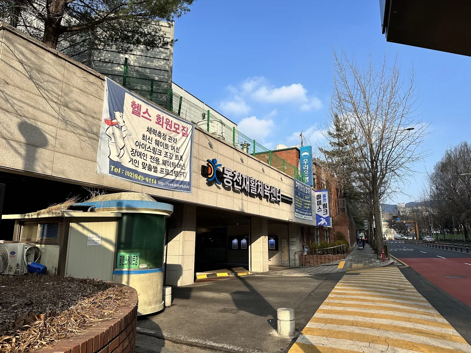 서울 노원구 동천스포츠센터의 정면. 입구 위에 간판과 현수막이 걸려 있고 옆에는 횡단보도가 있습니다. — Dongcheon Ice Rink