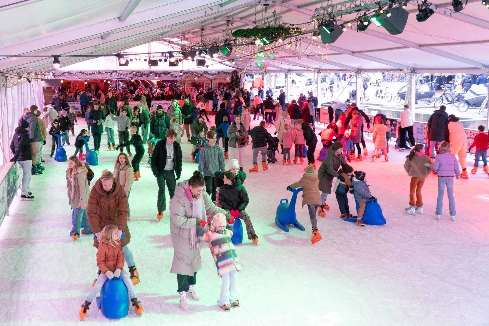 The ice under the tent roof of the Drijvende IJsbaan with skaters and skate aids — Drijvende IJsbaan Leiden