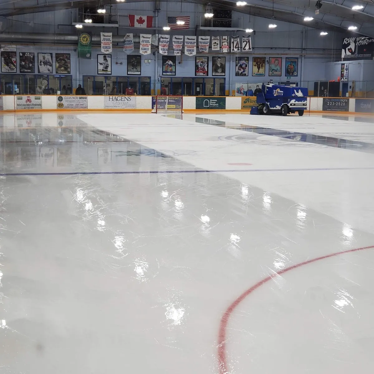 A clear stretch of Dryden Memorial Arena ice with a red line and dark kick-plated boards. — Dryden Memorial Arena
