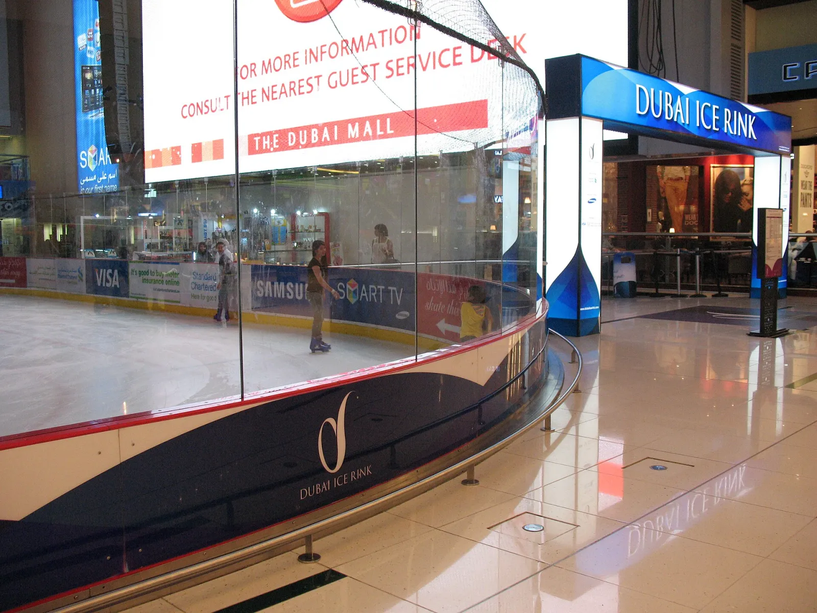 The Dubai Ice Rink entrance sign and glass boards at ground level in The Dubai Mall — Dubai Ice Rink