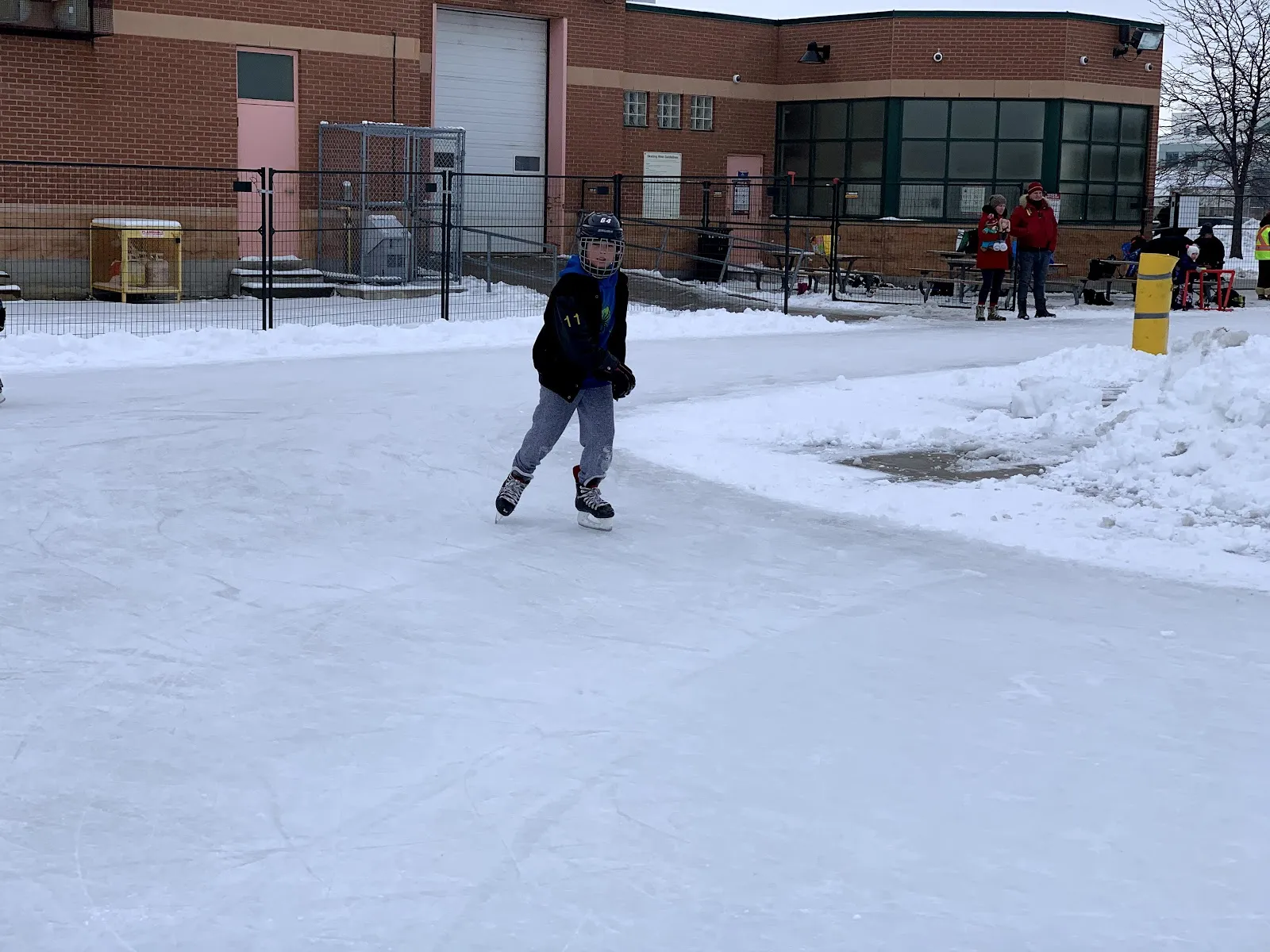 A skater on the snowy outdoor rink in front of the Dufferin Clark Community Centre in Vaughan — Dufferin Clark Community Centre Outdoor Rink (Vaughan)