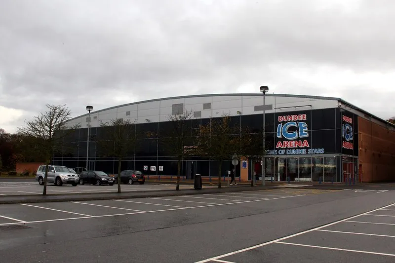 The curved-roof arena with its Dundee Ice Arena sign reading Home of Dundee Stars, seen across the car park. — Dundee Ice Arena