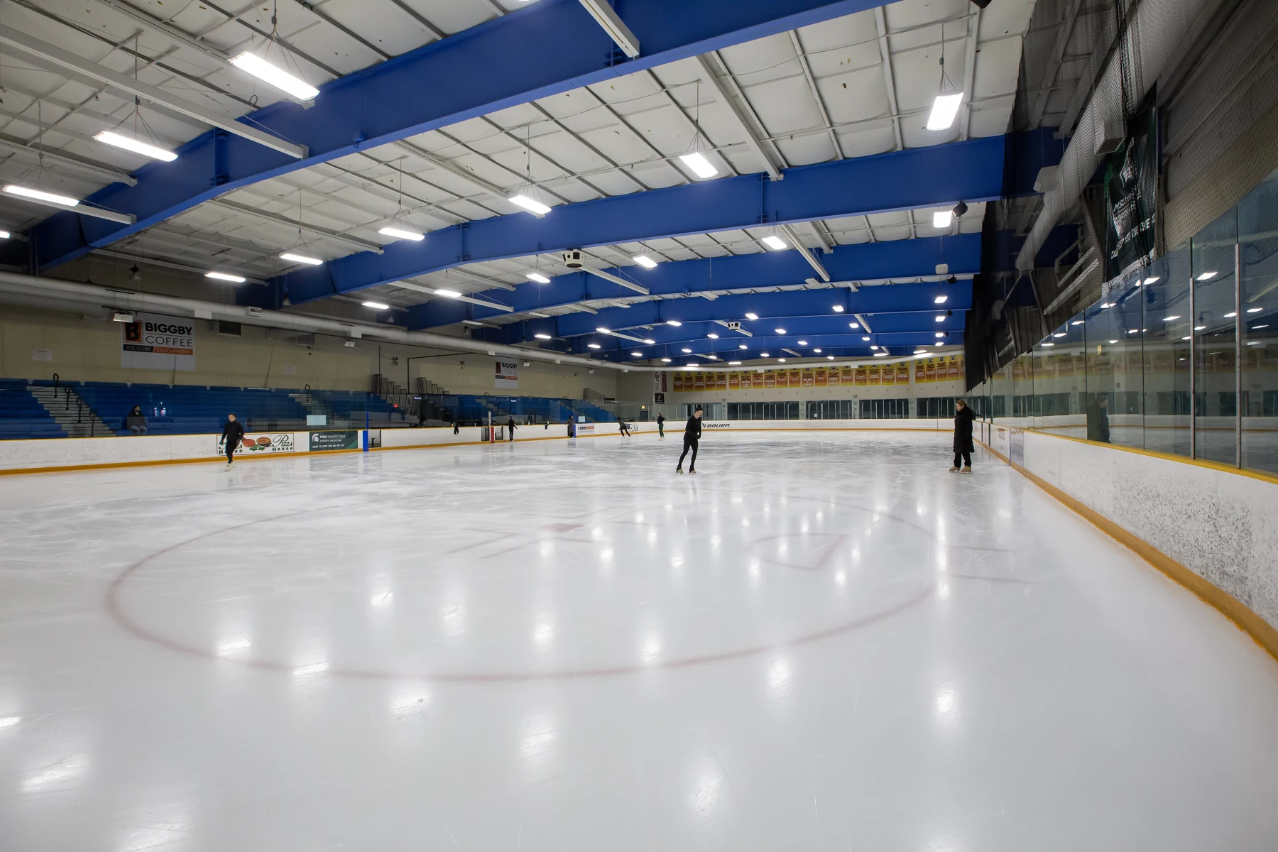 A wide view across the ice beneath East Lansing’s blue roof beams. — BIGGBY COFFEE Ice Cube - East Lansing