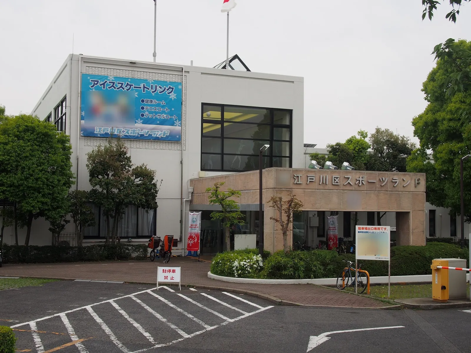 The front of Edogawa Sports Land in Higashi-Shinozaki, Edogawa, with the ice skating rink banner on the white building and the entrance gate in front — Edogawa Sports Land Ice Rink