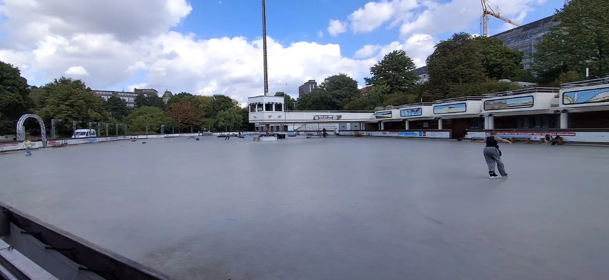 The open-air EisArena Hamburg and its chimney tower beside the Planten un Blomen park. — EisArena Hamburg