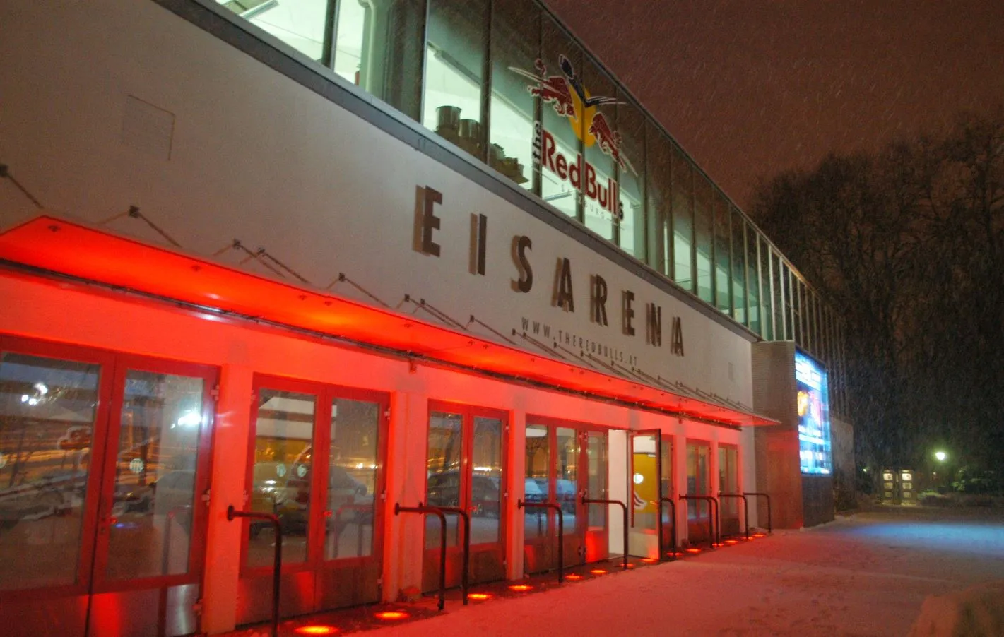 Die Eingangsfront der Eisarena im Volksgarten nach Einbruch der Dunkelheit. – Eisarena Salzburg im Volksgarten