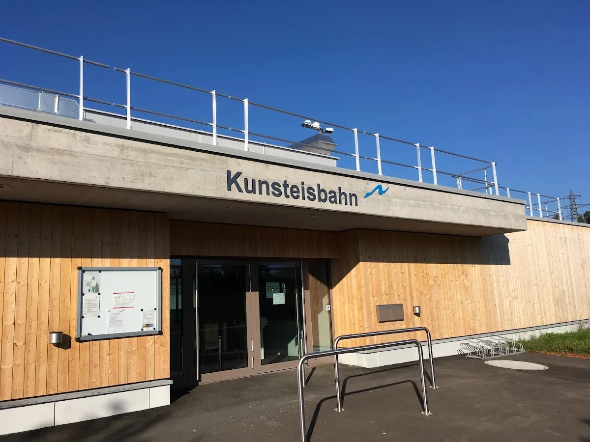 Das Eingangsgebäude der Kunsteisbahn Brand mit seiner Holzfassade und dem Schriftzug Kunsteisbahn – Eisbahn Brand