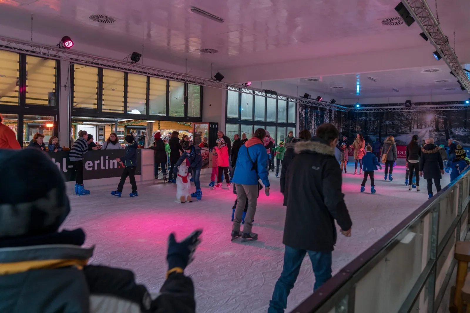 Skaters on the lit ice inside the roofed and glazed Eisbahn Rübezahl am Müggelsee. — Eisbahn Rübezahl am Müggelsee