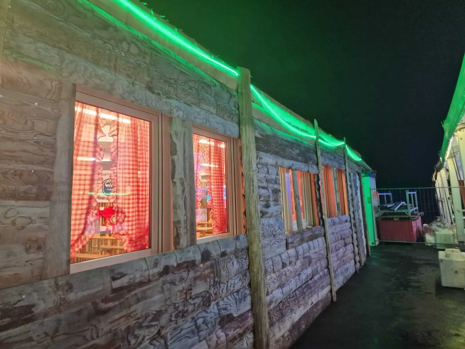 The wooden restaurant cabin beside the ice at Eisbahn Schüpfen at night — Eisbahn Schüpfen