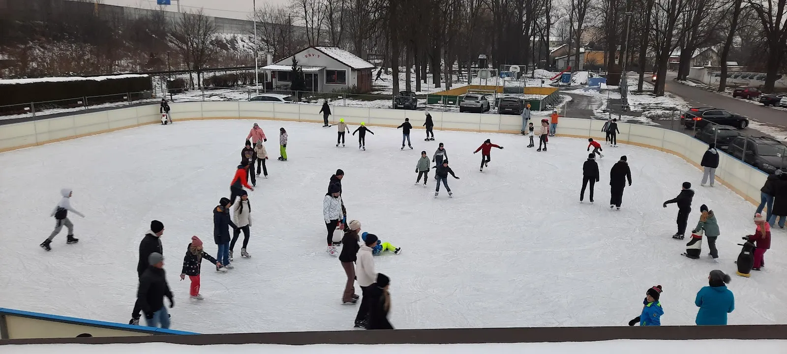 Skaters spread over the open-air ice of the Herzogenburg rink on a winter afternoon — Eislaufplatz Herzogenburg