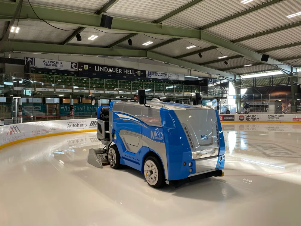 The resurfacer on the ice in the Eissportarena Lindau (BPM-Arena), with the boards and stands behind it under the steel roof — Eissportarena Lindau (BPM-Arena)