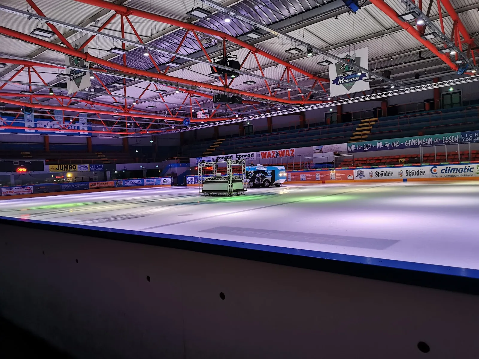 The ice surface of the Eissporthalle Essen-West seen over the boards, with the ice resurfacer at the far side — Eissporthalle Essen-West
