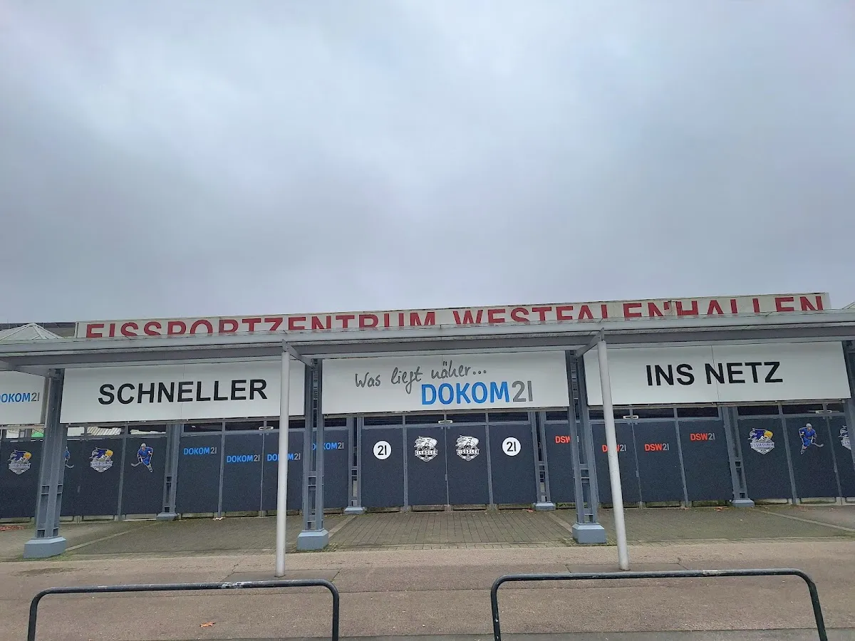 The entrance front of the Eissportzentrum Westfalenhallen in Dortmund under its red lettering. — Eissportzentrum Westfalen
