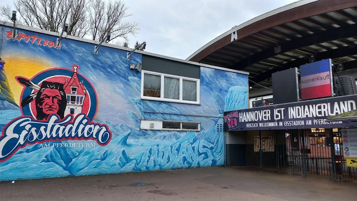 The mural-painted front of the Eisstadion am Pferdeturm in Hannover beside the entrance canopy. — Eisstadion am Pferdeturm