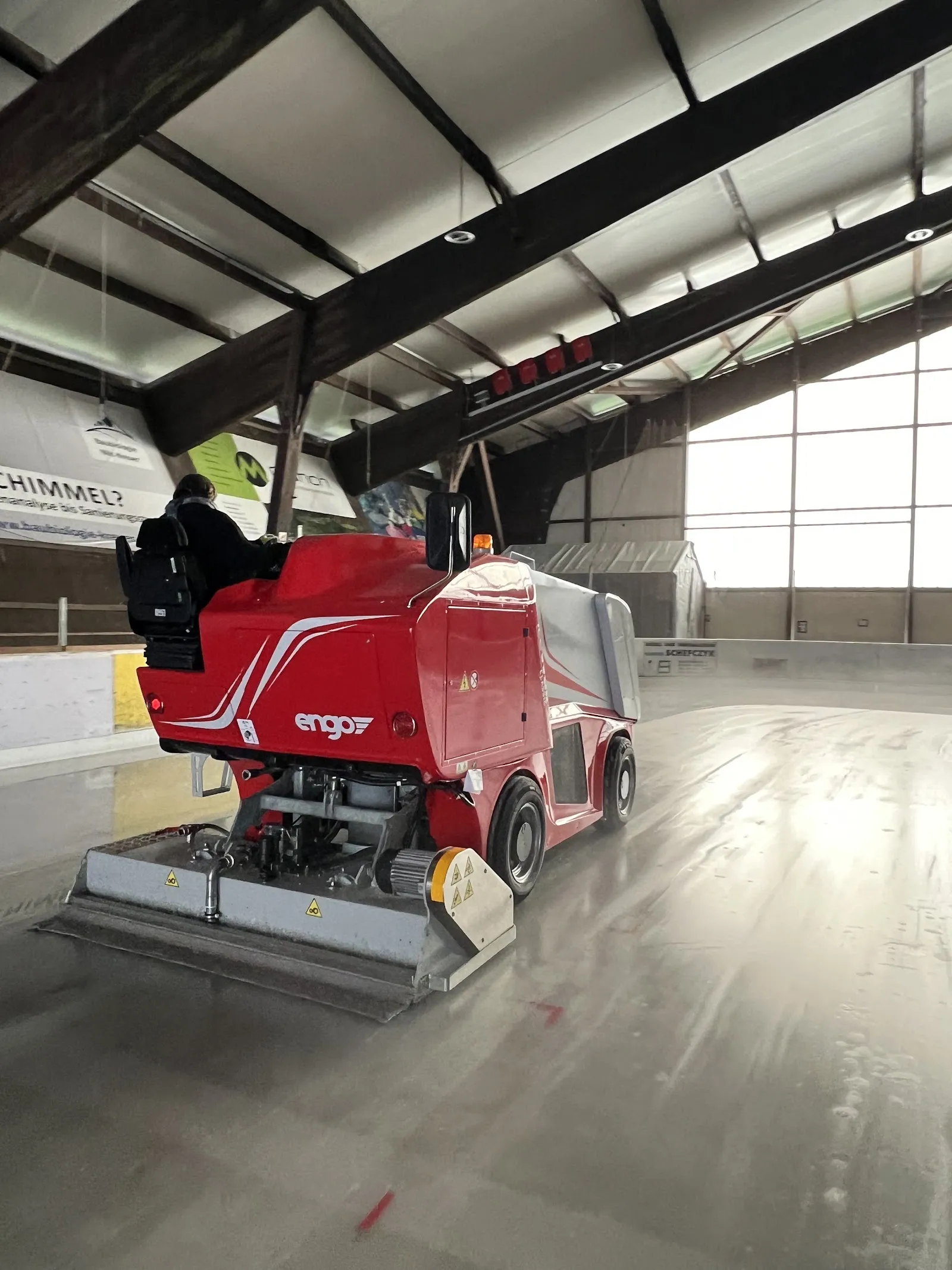 Die Eismaschine bei der Arbeit auf dem Eis im Eisstadion Wernau unter den dunklen Holzdachbalken – Eisstadion Wernau