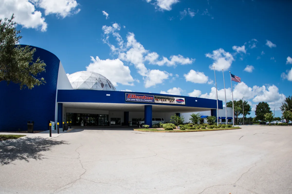 Front of the building shot from across an empty asphalt parking lot — Ellenton Ice and Sports Complex