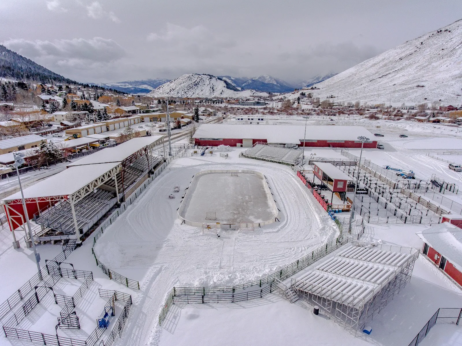 Aerial view of the rink on the Teton County Fair and Rodeo Grounds in snow, grandstand beside it — Fairgrounds Ice Rink