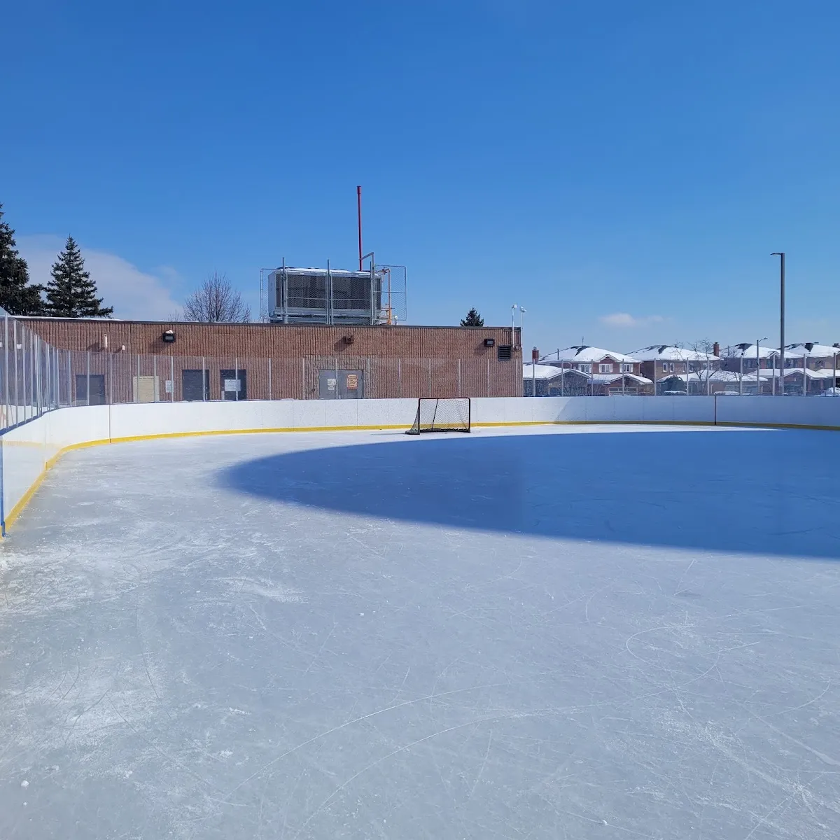 The boarded outdoor rink at Father Bulfon on a bright winter day — Father E. Bulfon Community Centre Outdoor Rink (Vaughan)