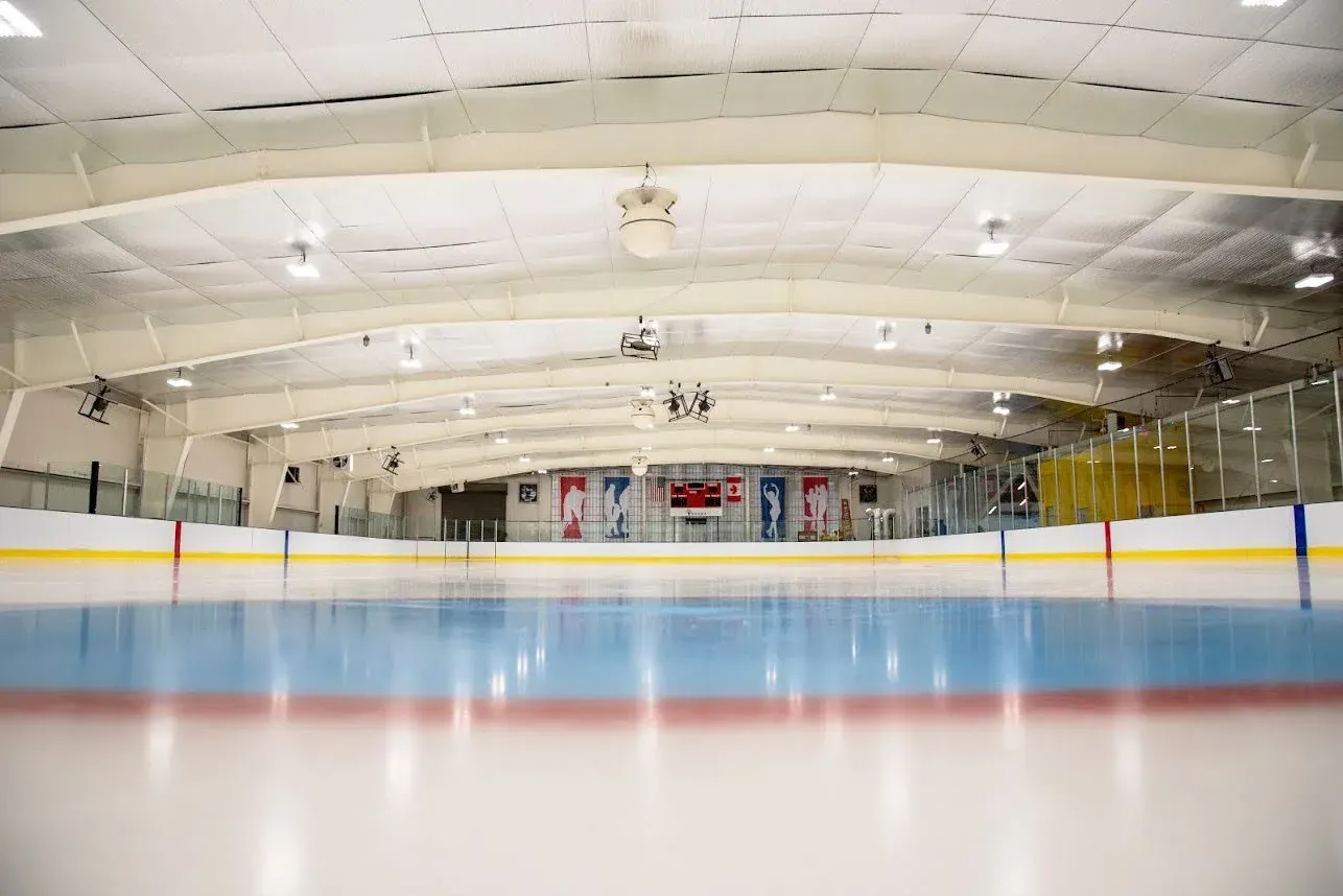 Empty ice beneath the arched white ceiling — Flo Fabrizio Ice Center
