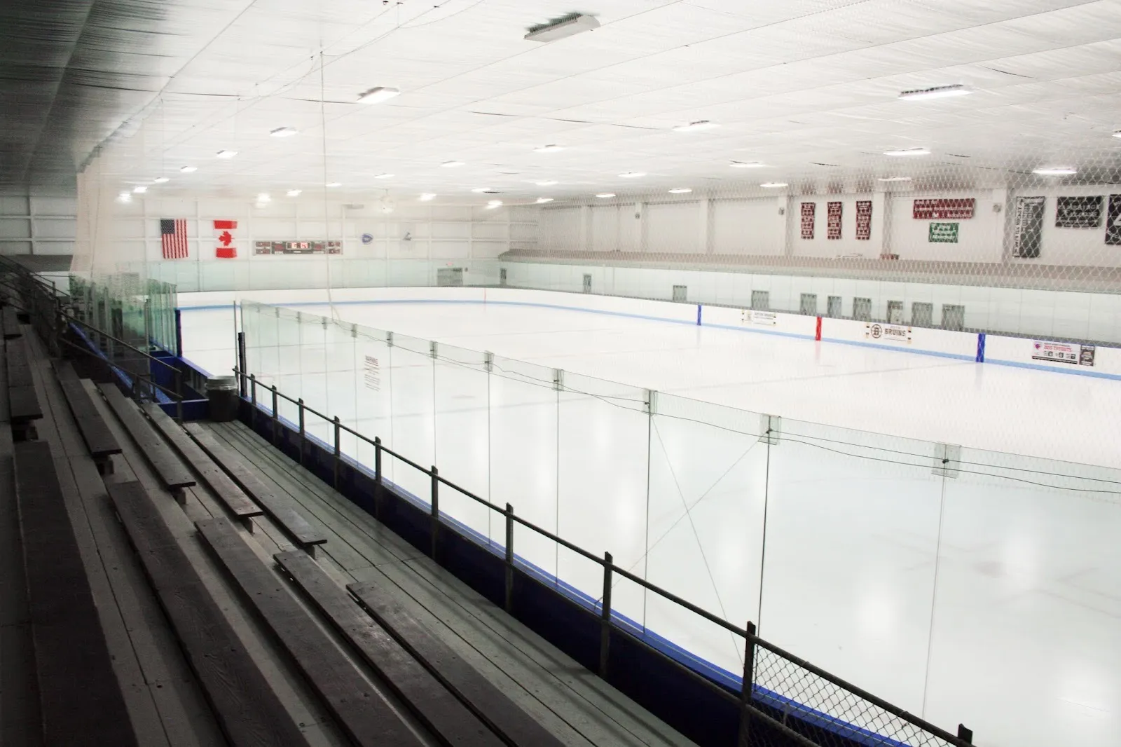 El hielo vacío de la Simoni Skating Rink en Cambridge, visto desde las gradas a través del vidrio y la red — Simoni Skating Rink