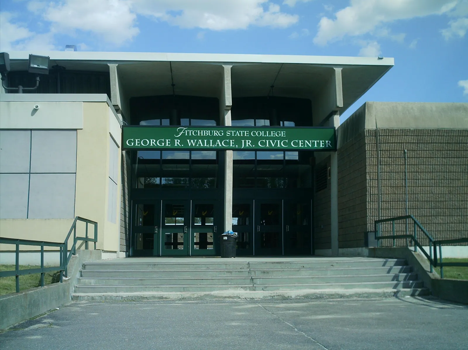 Building entrance with a green sign reading "Fitchburg State College, George R. Wallace, Jr. Civic Center" over the glass doors, concrete steps in front. — Wallace Civic Center