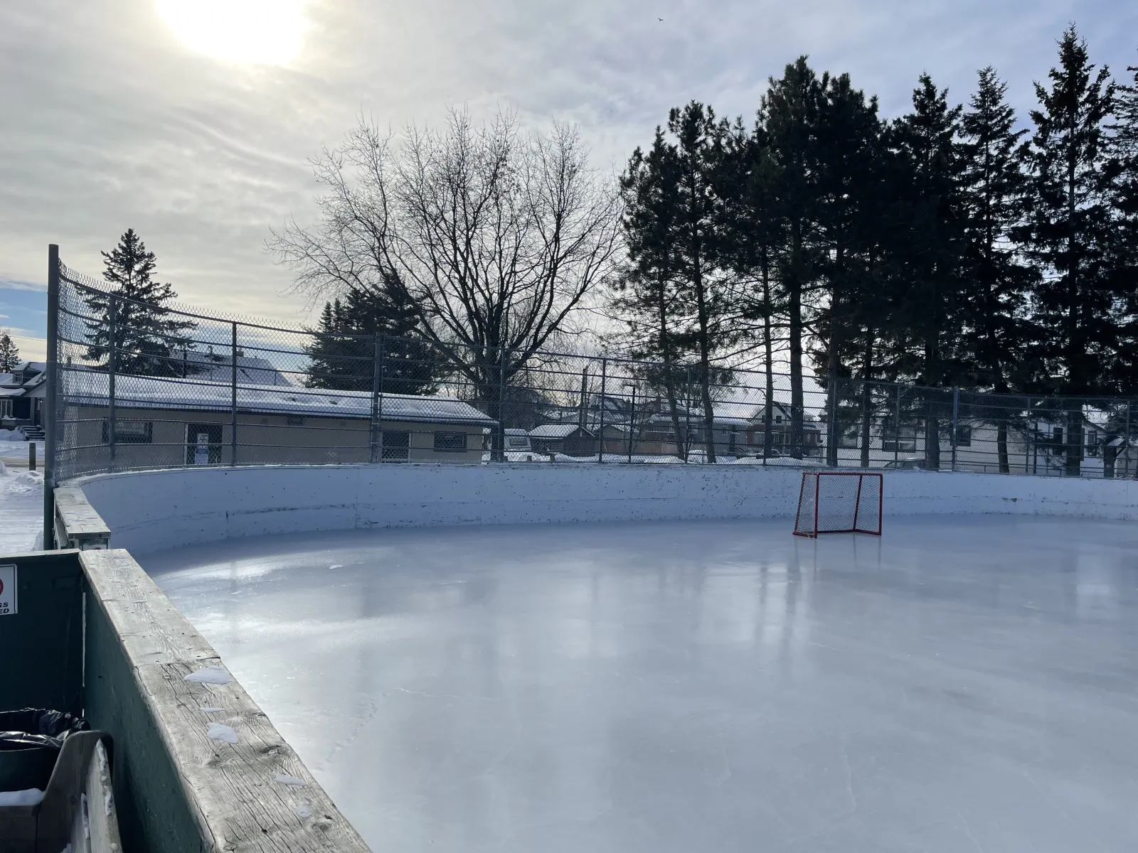 The boarded rink at Frank Charry Park with a goal and a clear sheet of ice — Frank Charry Park Outdoor Rink