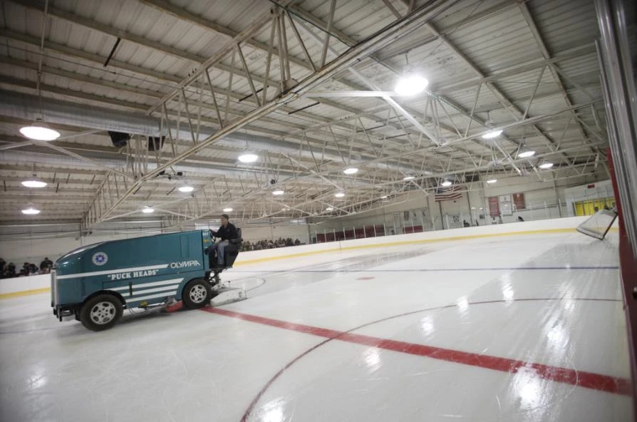 An Olympia ice resurfacer crossing the Frank Southern ice surface beneath steel roof trusses. — Frank Southern Ice Arena