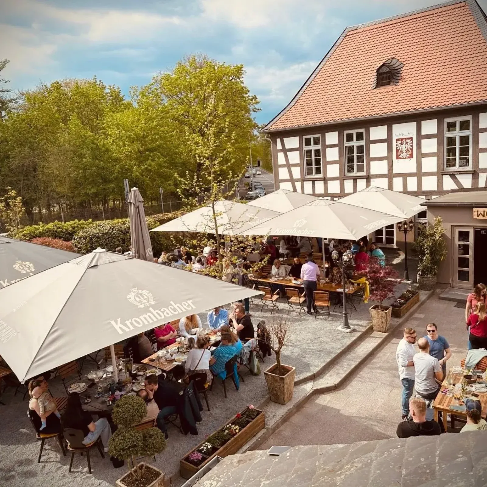 The half-timbered Frankfurter Haus with its red tiled roof, seen across the terrace and garden. — Eislaufbahn im Frankfurter Haus