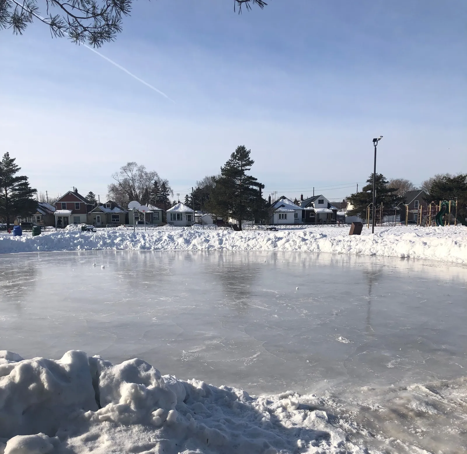 El estanque de patinaje de Franklin Park con una superficie de hielo y casas más allá — Franklin Park Skating Pond