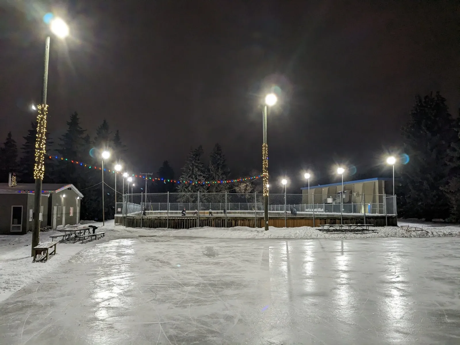 The Fulton Place community rink at night, with floodlights over the boards and a smooth ice surface — Fulton Place Community League Rink